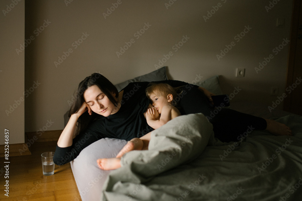 Woman breastfeeding baby on the bed