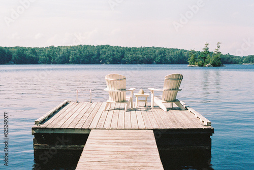 Two Chairs Sit on a Dock on a Summer Day in Biscay Pond in Maine  