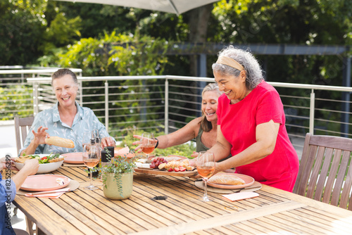 Diverse senior female friends enjoying meal outdoors