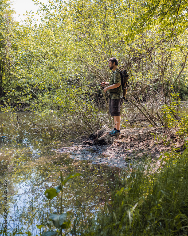 Recreational fisherman at river bank trying to catch a fish. Angler lifestyle concept. Recreational fisherman at river bank trying to catch a fish. Angler lifestyle concept.