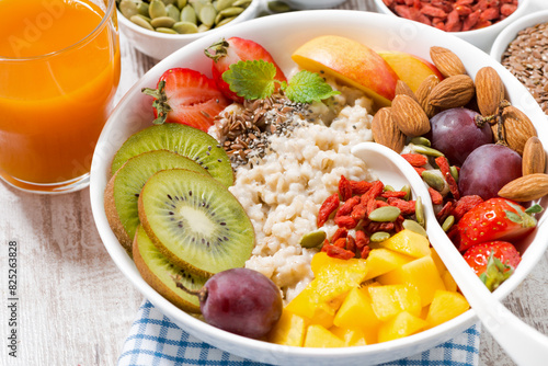 oatmeal porridge with fresh fruit and superfoods for healthy breakfast, closeup