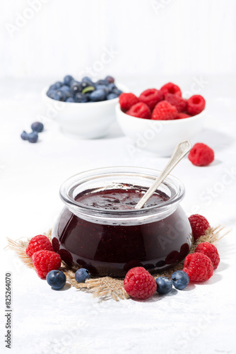 raspberry and blueberry jam in a glass jar, vertical