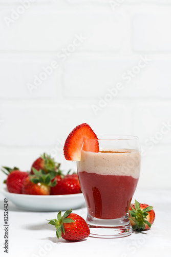 sweet strawberry yoghurt milkshake on white table, vertical