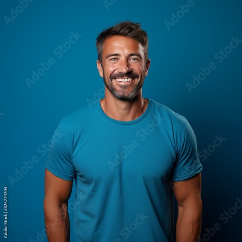 a happy medium age man wearing blue shirt in front of a blue background