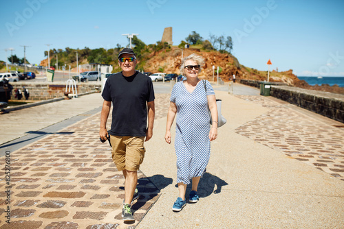 Smiling couple walks along the promenade by the sea photo