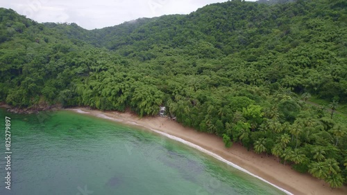 Drone flying away from lonely house surrounded by water and trees photo