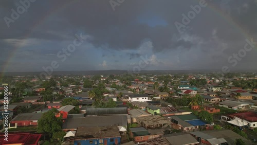 Drone Flying Over Village Towards Rainbow photo