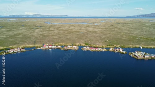 Coastal village floating home of Uros people in Bolivia on shore edge, aerial photo