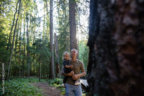 Man and his child on his shoulders the dense forest photo