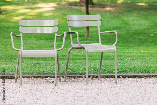 Two empty green chairs in the Parisian park