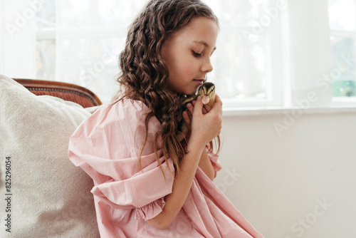 A young girl holds a little chick in her arms photo