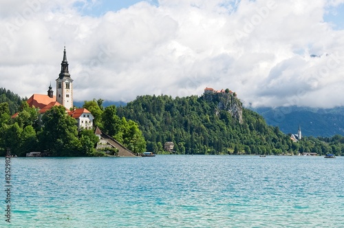 The church on Lake Bled and in the distance, on the slope, the Bled Castle