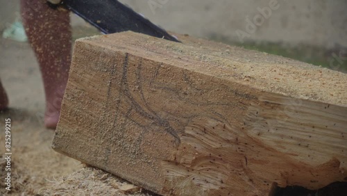Man Cutting The Wood With A Chainsaw At His Workshop Before Carving. - close up shot photo