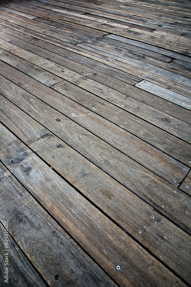 New dark wooden floor slats for outdoor use with a diagonal course fixed with steel screws New dark wooden floor slats for outdoor use with a diagonal course fixed with steel screws