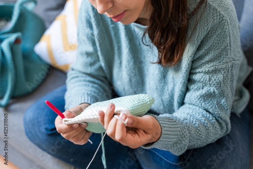 Cozy handicraft time: woman crocheting at home photo
