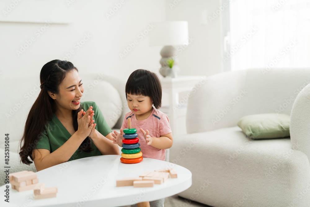 mom helps baby daughter collect a toy pyramid mom helps baby daughter collect a toy pyramid