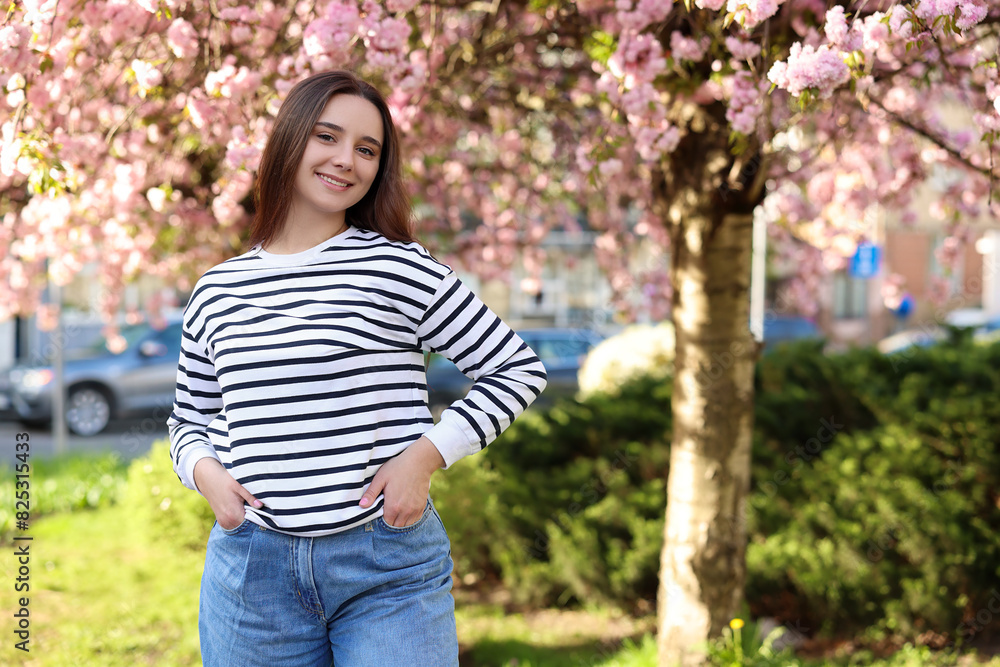 Beautiful woman near blossoming tree on spring day, space for text Beautiful woman near blossoming tree on spring day, space for text