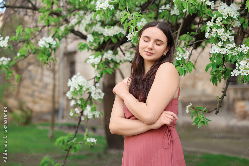 Beautiful woman near blossoming tree on spring day Beautiful woman near blossoming tree on spring day