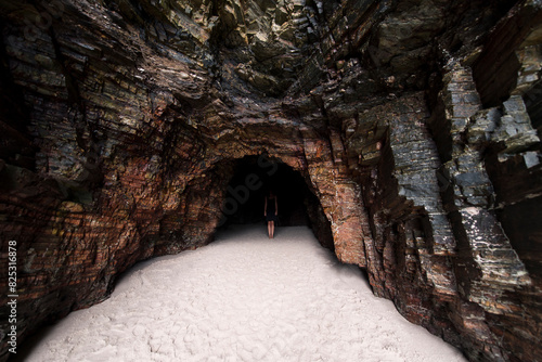 Surreal portrait of woman in dark beach cave photo