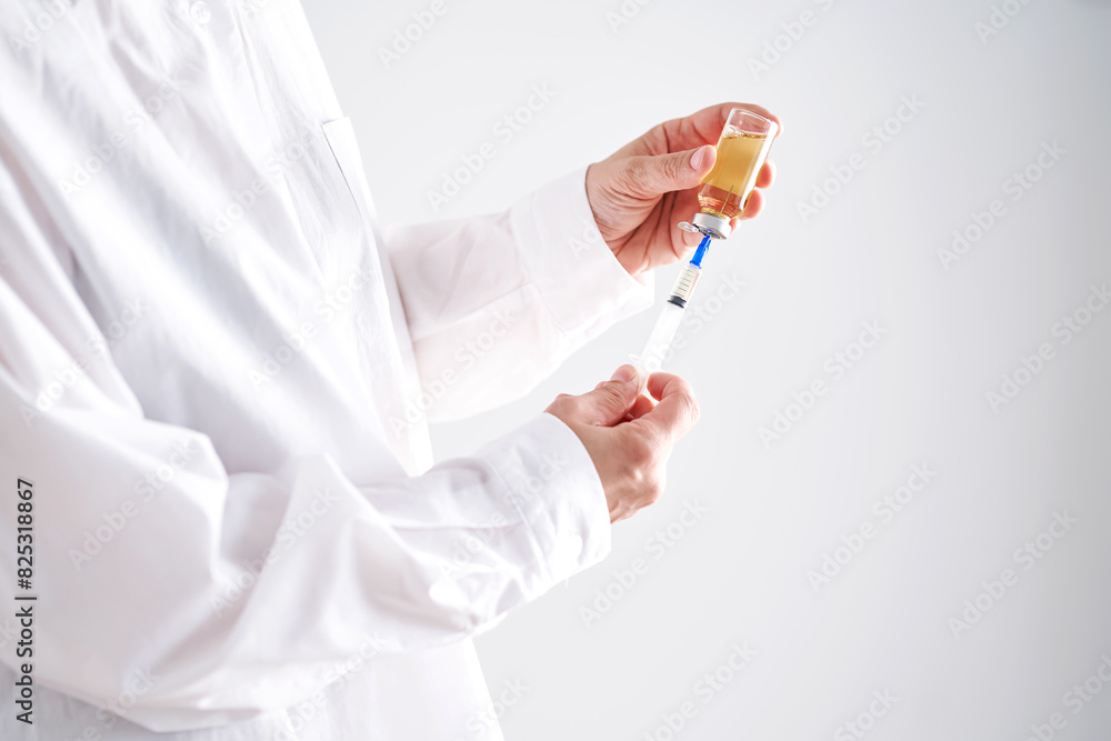 The doctor draws a medicine into a syringe. Anonymized photo. The doctor draws a medicine into a syringe. Anonymized photo.