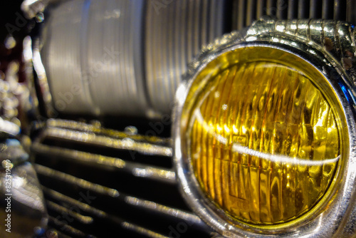 old car headlight in yellow color , closeup view photo