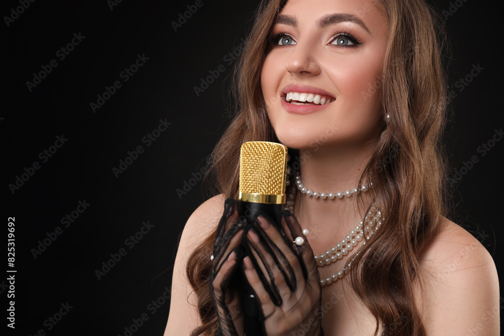 Beautiful young jazz singer with microphone on black background Beautiful young jazz singer with microphone on black background