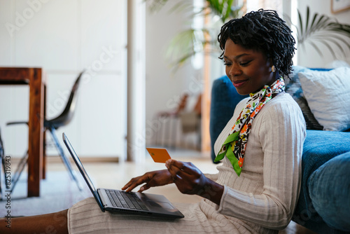 Woman shopping online sitting on floor at home photo