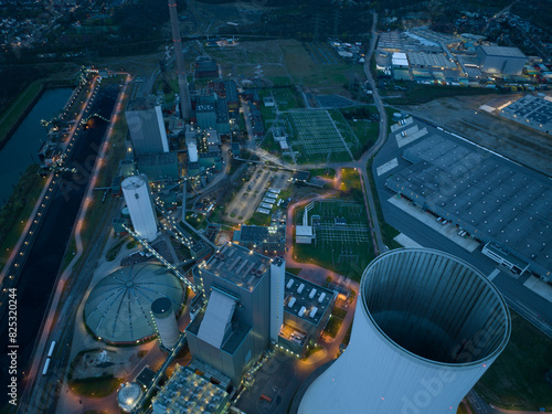 Aerial drone view on a fossil fueled power plant at dusk and night. Cooling tower exterioir close up detail view. Duisburg, Germany. CLose up industrial installation. photo