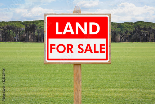 Land For Sale - Real estate concept with a vacant lot for sale available for building construction - Land plot managemen twith an advertising billboard in a rural scene photo