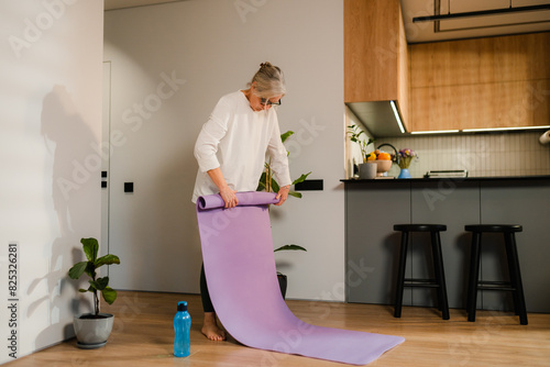 A woman lays out a gymnastic mat photo