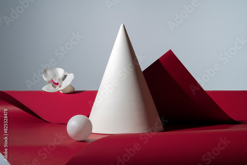White sphere, cone and flower on red background. Geometric stil life photo