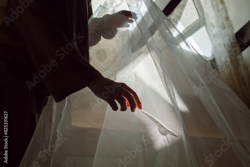 hands smoothing fabric against the light