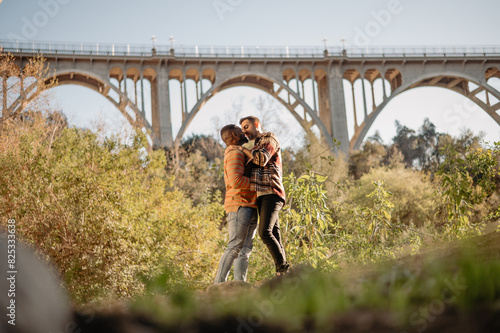 LGBTQ+ couple kissing outdoors in nature photo