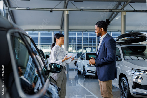 Two car dealership employees having a conversation in the showroom