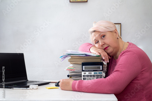 Accountant is tired of doing her job with the report. photo