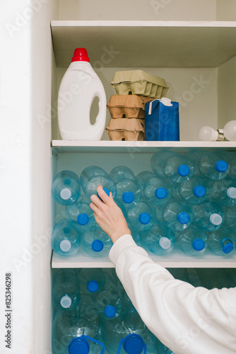 Hand places a plastic bottle on a shelf next to other recyclables. 