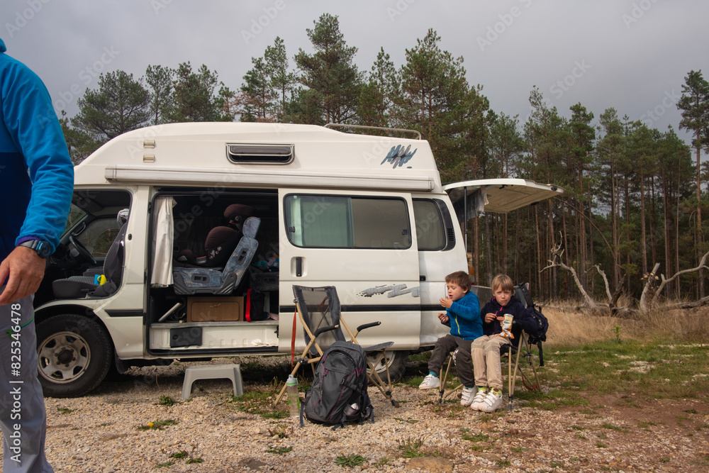 Young boys having snacks by the camper Young boys having snacks by the camper
