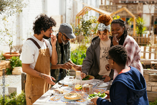 Diverse friends having lunch in community garden photo