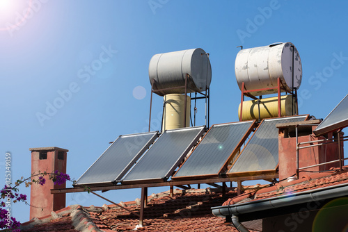 Solar energy panels on the top house roof. Green alternative energy and environment protection ecology concept - solar battery panels for warming water