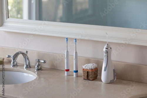 Electric Toothbrush next to sink  still life with water flosser  photo