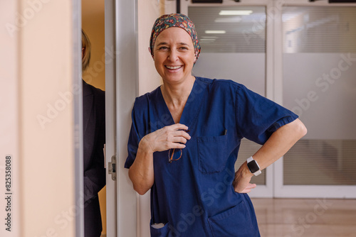 Confident female surgeon smiling in hospital corridor