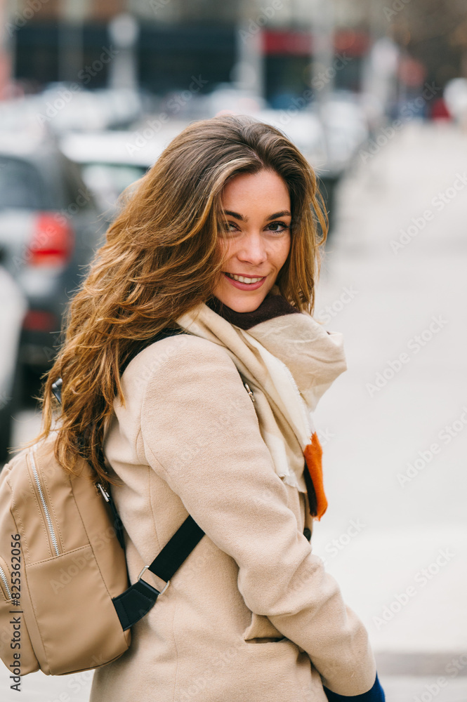 Charming woman smiling on city street with casual style Charming woman smiling on city street with casual style