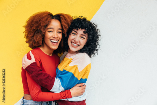 Joyful embrace between friends with colorful background photo