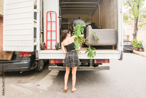 Woman loading houseplant into movers truck photo