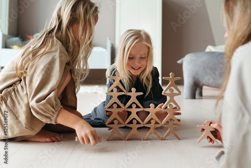Children play with a wooden construction set together photo