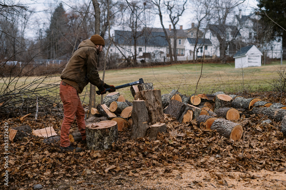 man splitting wood in his backyard with an axe man splitting wood in his backyard with an axe
