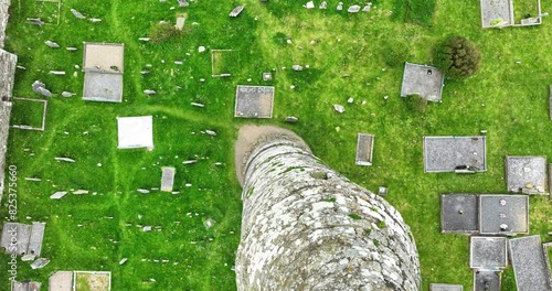 Ireland Epic locations drone flying down the side of Ardmore Round Tower with graves in Ardmore Village in Waterford photo