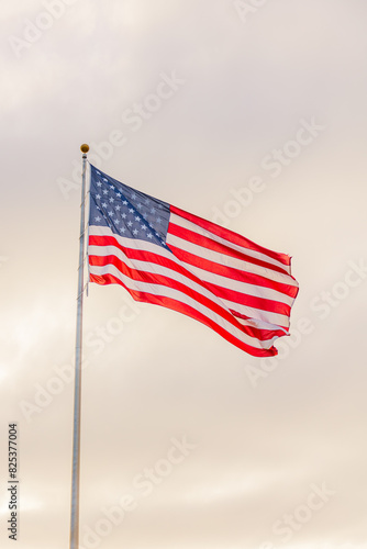 American flag waving against a cloudy sky