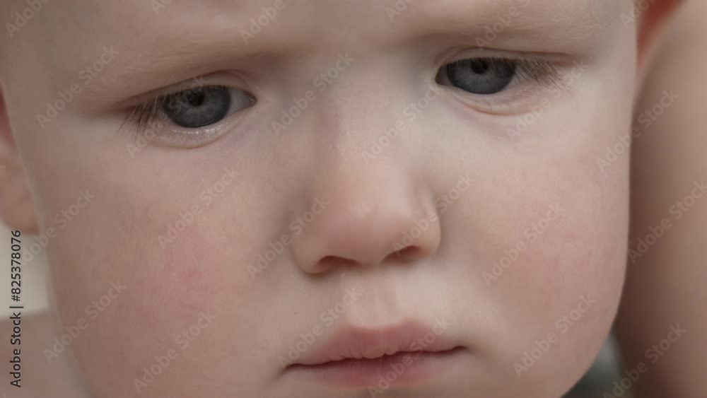 The little boy looks down intently. Sad eyes of a child close-up. Slow motion. High quality 4k footage The little boy looks down intently. Sad eyes of a child close-up. Slow motion. High quality 4k footage