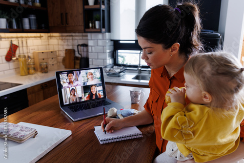 Working mother with daughter attending online meeting